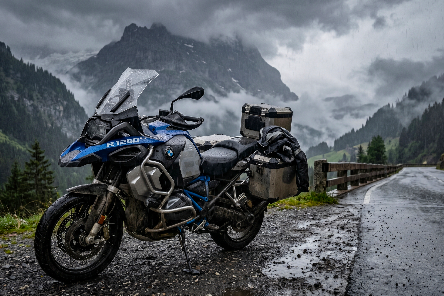 A BMW GS motorcycle parked on top of a cliff with a misty hill in the background.