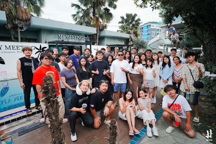 HUGTEAM posing for a photo poolside with a building and palm trees in the background.